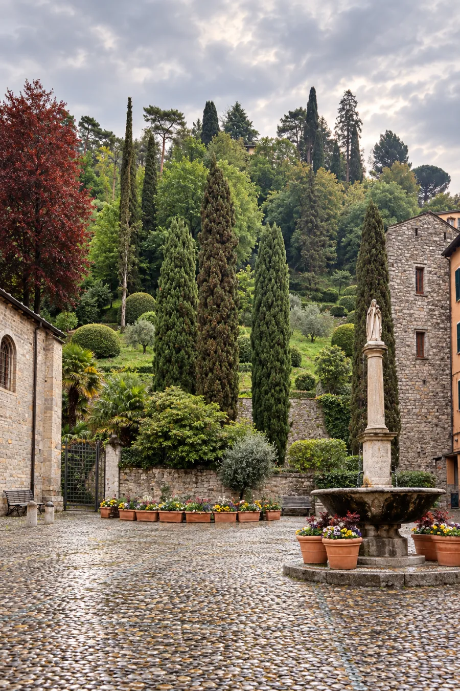 Piazza della Chiesa a Bellagio: i ciottoli, la fontana di pietra, il giardino di cipressi che sale sul promontorio.